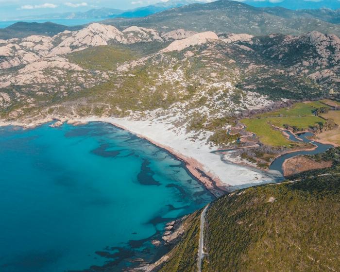 Vue aérienne d'une plage en Corse avec les montages en arrière plan