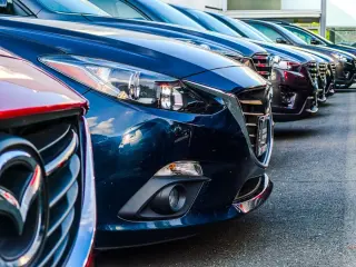Plusieurs voitures garées les unes à côté des autres dans un parking
