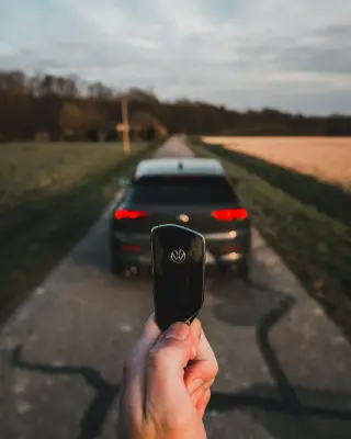 Main d'un homme montrant des clés de voiture