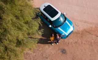 Vue en hauteur de deux femmes à côté d'une voiture bleue