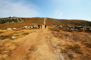 Trois hommes marchent sur un chemin de terre en Corse