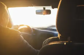 Intérieur d'une voiture vue passager sur le rétroviseur avec un coucher de soleil