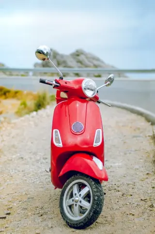 Scooter rouge garée en face de la mer