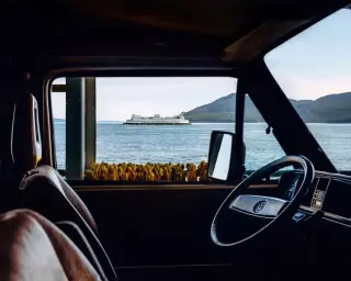 Vue depuis l'intérieur d'une voiture face à la mer avec un bateau