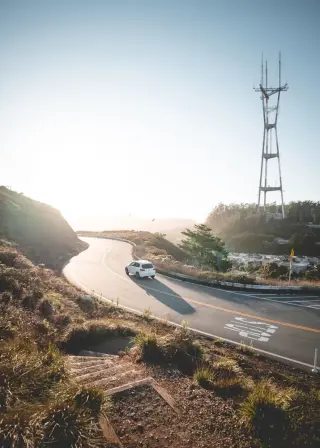 Voiture blanche roulant sur une route sinueuse