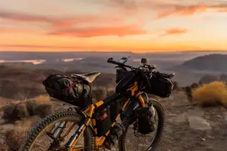 Un vélo jaune dans un paysage méditerranéen surplomblant la mer
