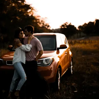 Un couple devant une voiture de location