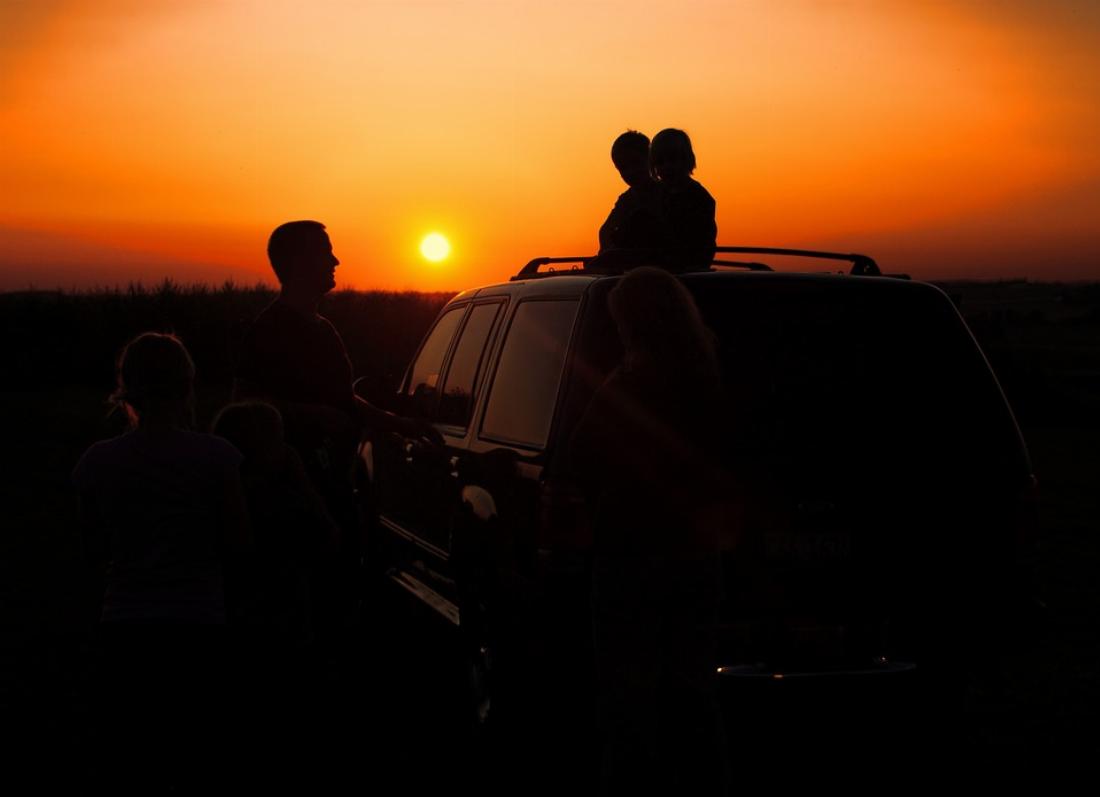 Une famille et une voiture de location au coucher de soleil