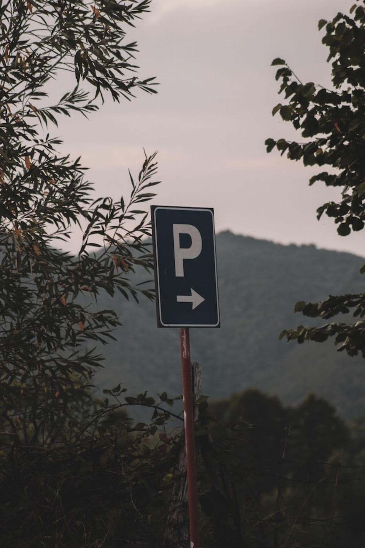 Panneau indiquant un parking au milieu des arbres