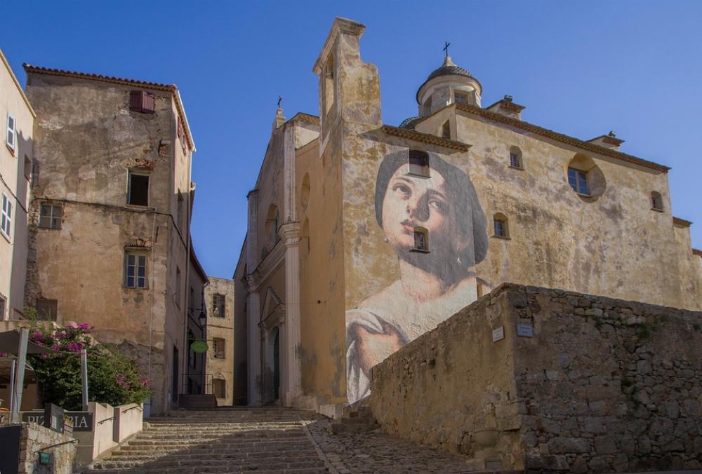 Une rue de la ville de Bastia en Corse avec une fresque murale représentant une femme