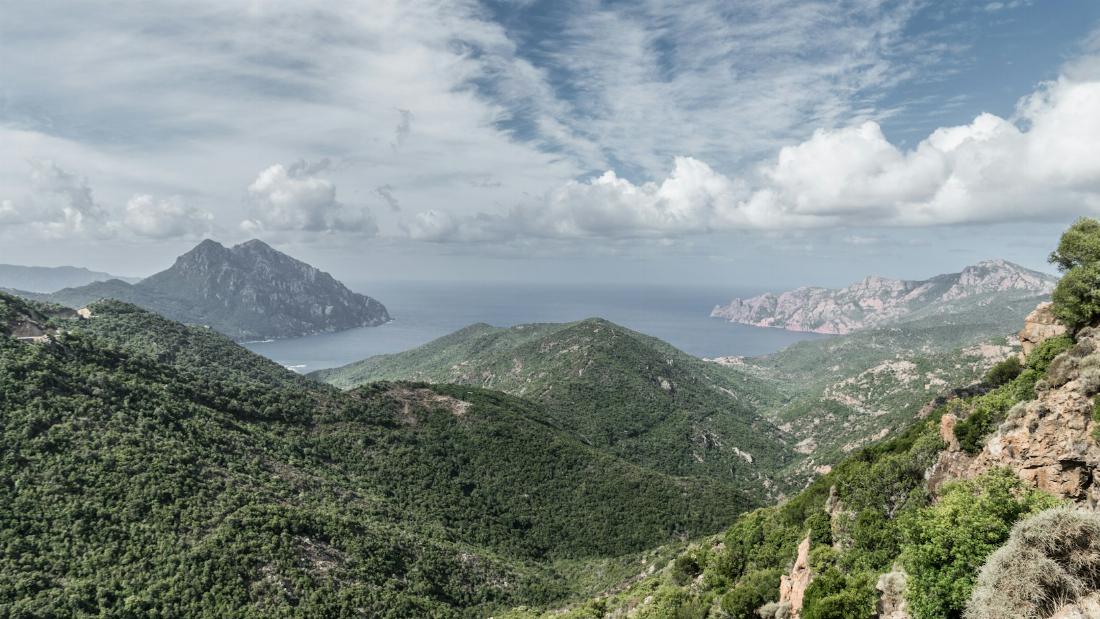 Vue panoramique des montagnes en face de la mer avec le ciel et les nuages en Corse